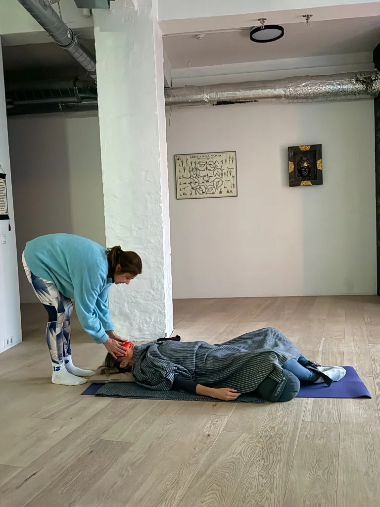 Liis Ugandi поправляет лежащую ученицу с повязкой на глазах. Goyoga Tallinn.
